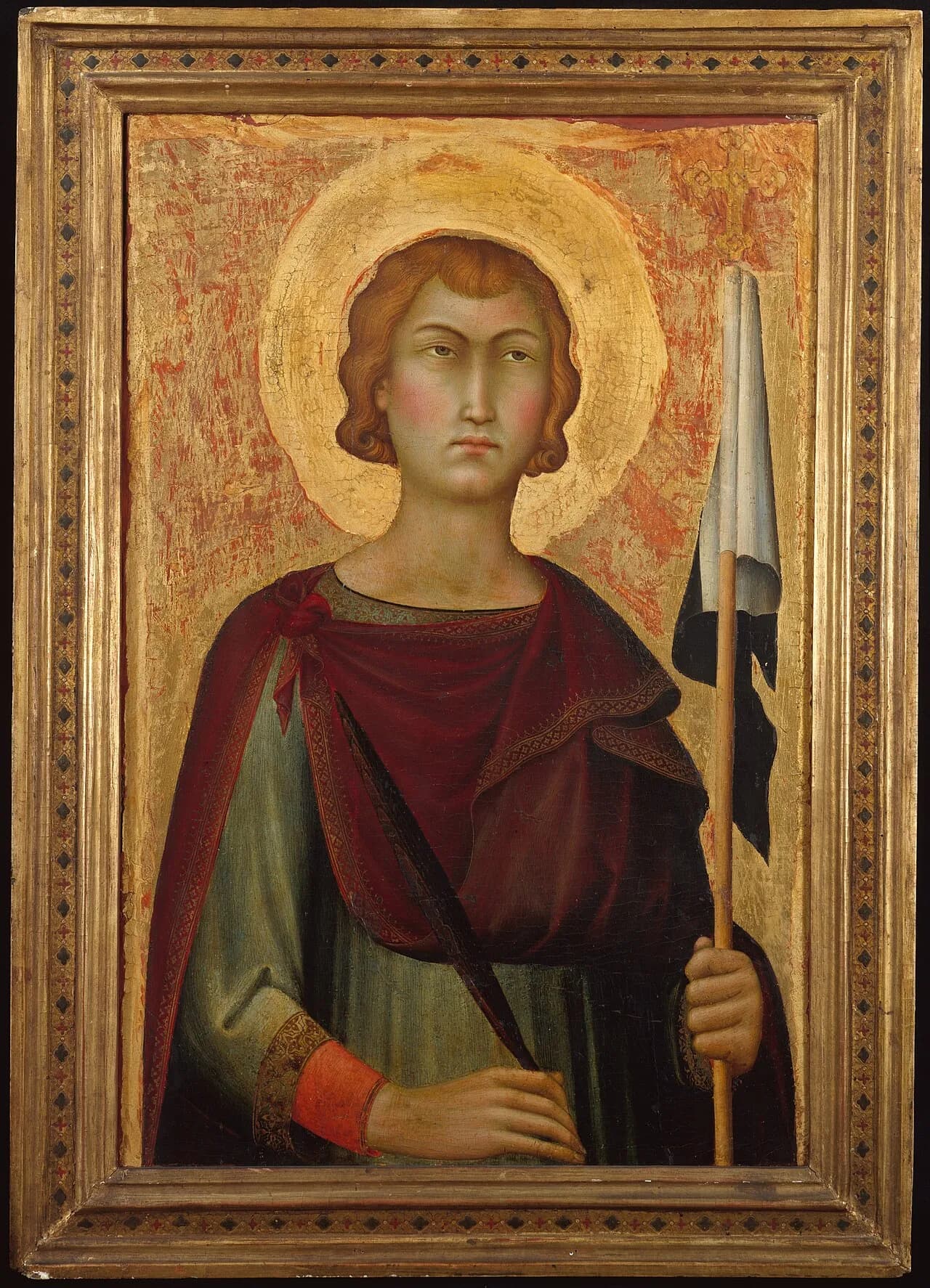 Painted panel on a gold ground of a beardless young man with reddish curls and a halo, in a green tunic and dark red cloak, holding a martyr's palm in one hand and a staff with a black-and-white banner in the other