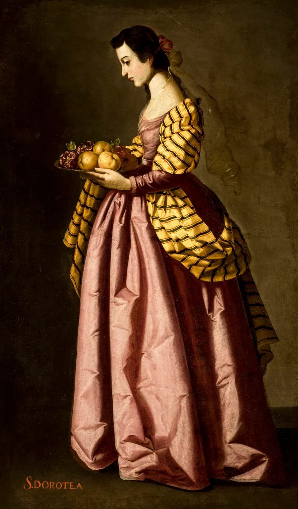 A young woman shown in profile, in a long pink gown with a yellow and black striped mantle and a sheer veil, carries a dish of apples and red roses against a dark background, with "S. DOROTEA" lettered at the bottom left
