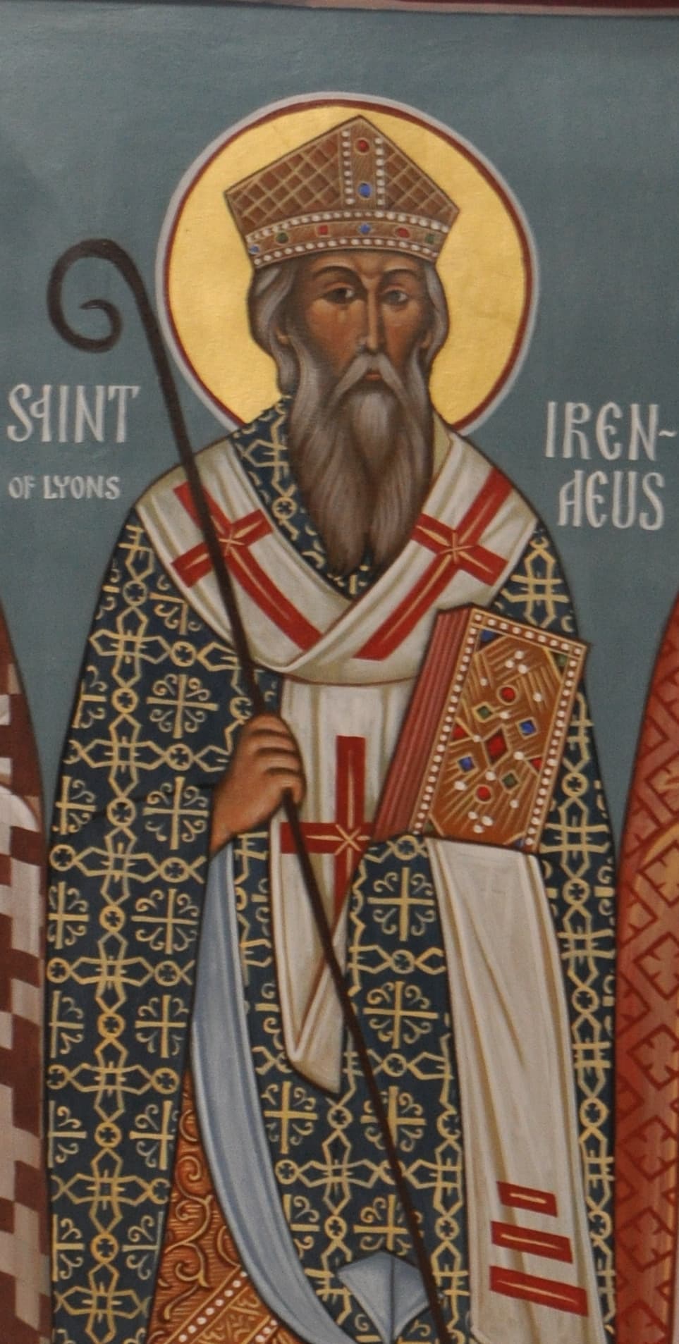 An icon of Irenaeus of Lyons as a bishop in a cross-patterned omophorion, holding a scroll, his name lettered beside his head