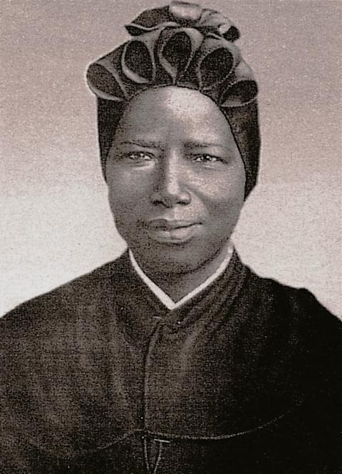 A photographic portrait of Josephine Bakhita in her Canossian habit and headdress, looking directly at the camera