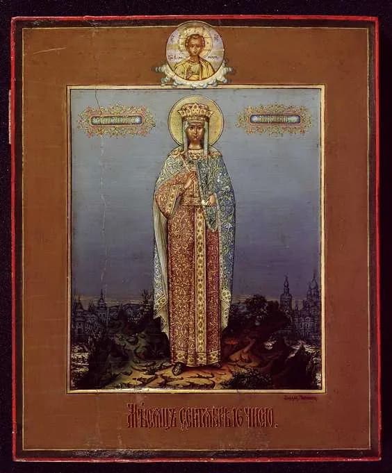 A Russian icon of Saint Ludmila standing crowned and haloed in a long red and gold robe and a green mantle, with church domes on the horizon behind her and a small medallion of Christ above her head