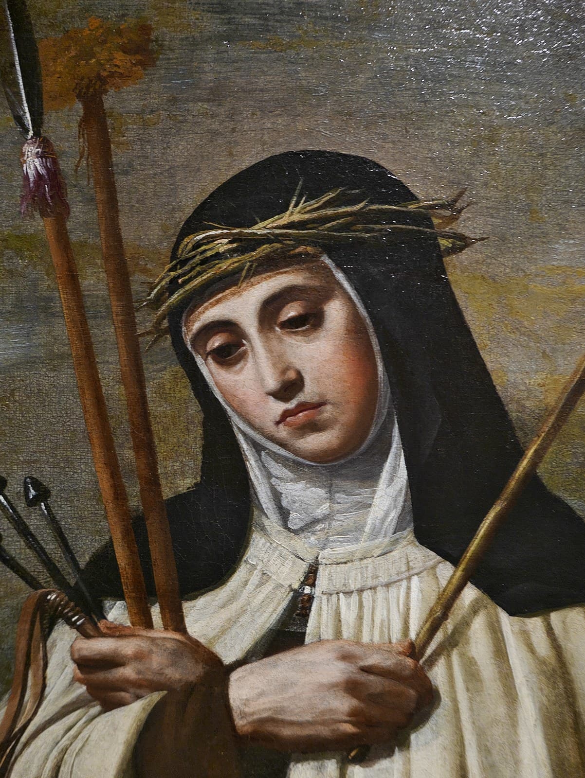 A detail from Alonso Cano's painting of Mary Magdalene de' Pazzi in the brown and white Carmelite habit, her head inclined, a crown of thorns and arrows held against her