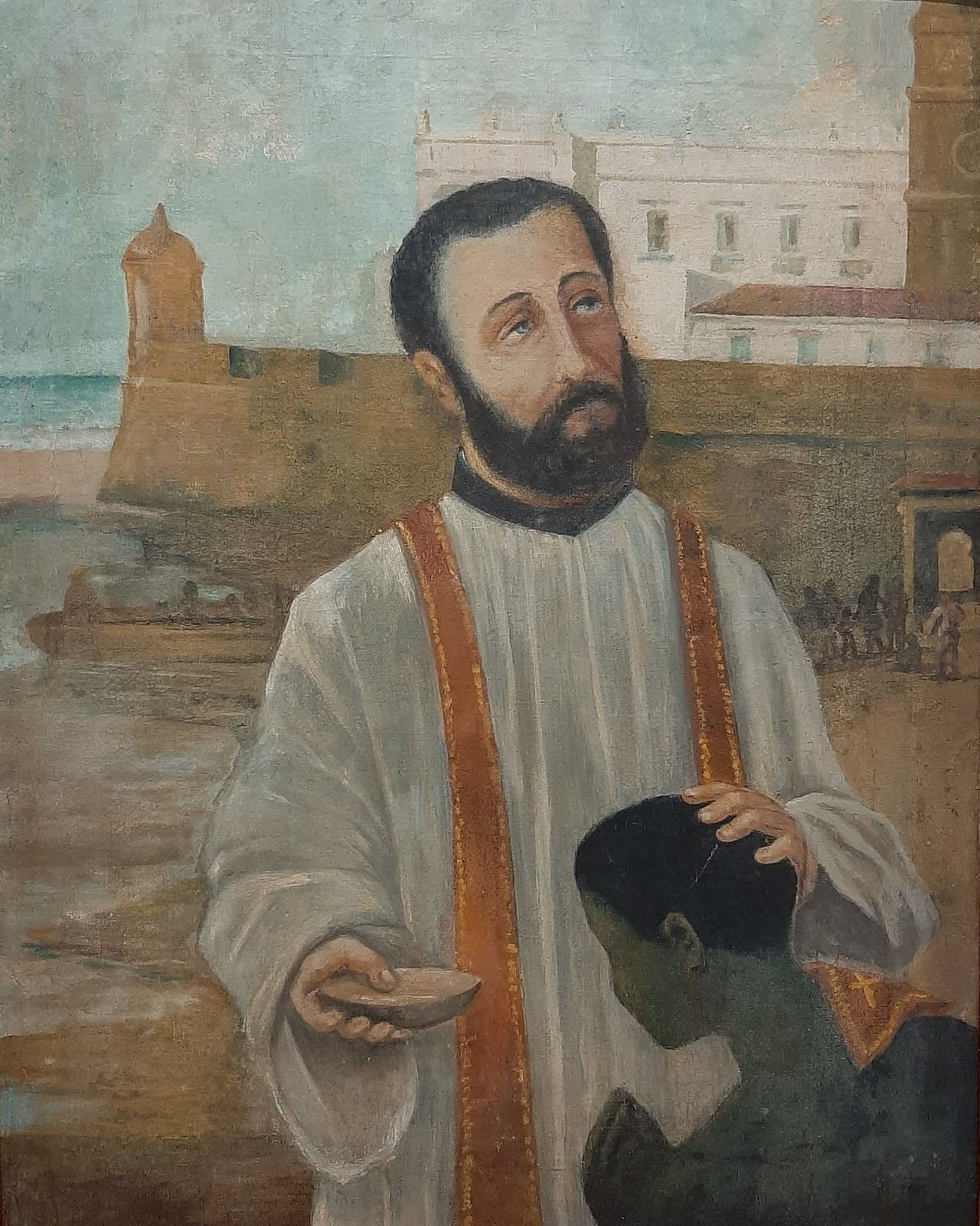 A painting of Peter Claver in a Jesuit cassock and stole beside a kneeling African man, the harbor of Cartagena behind them