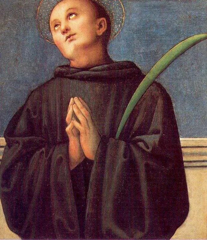 Renaissance panel painting of a young tonsured monk in a black habit with a gold halo, looking upward with his hands joined in prayer and a green martyr's palm resting against his shoulder, against a blue sky above a low stone parapet