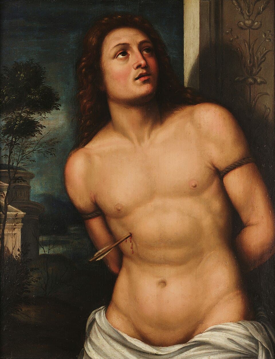 A Renaissance painting of Saint Sebastian as a beardless young man bound by the arms to a column, a single arrow in his side, looking upward against a dark evening landscape