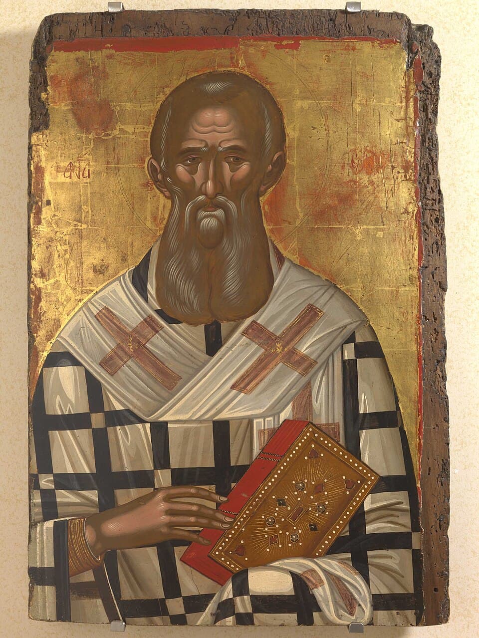 An icon of a gray-bearded Eastern bishop in a white omophorion marked with crosses, holding a jeweled gospel book, painted by Michael Damaskenos