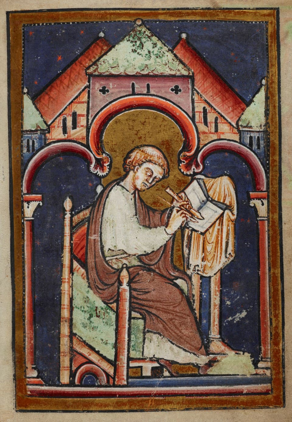 A twelfth-century manuscript miniature of a tonsured monk with a halo, seated and writing with a quill at a lectern, monastery roofs behind him against a starred blue ground