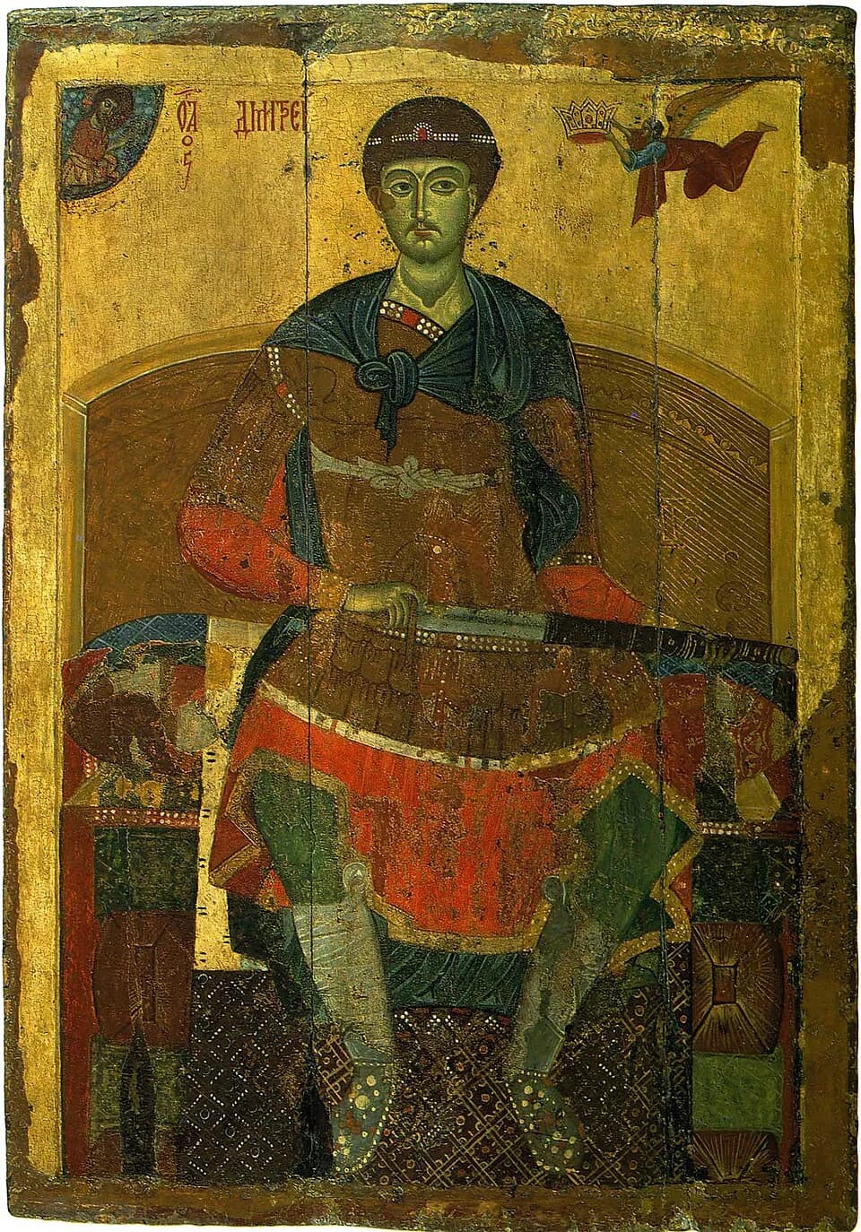 Medieval Russian icon on a gold ground of a young man with short dark hair and a jeweled band on his head, seated on a cushioned throne in a red tunic and dark blue cloak, drawing a sword from its scabbard across his knees, while a small angel at the upper right flies toward him holding a crown
