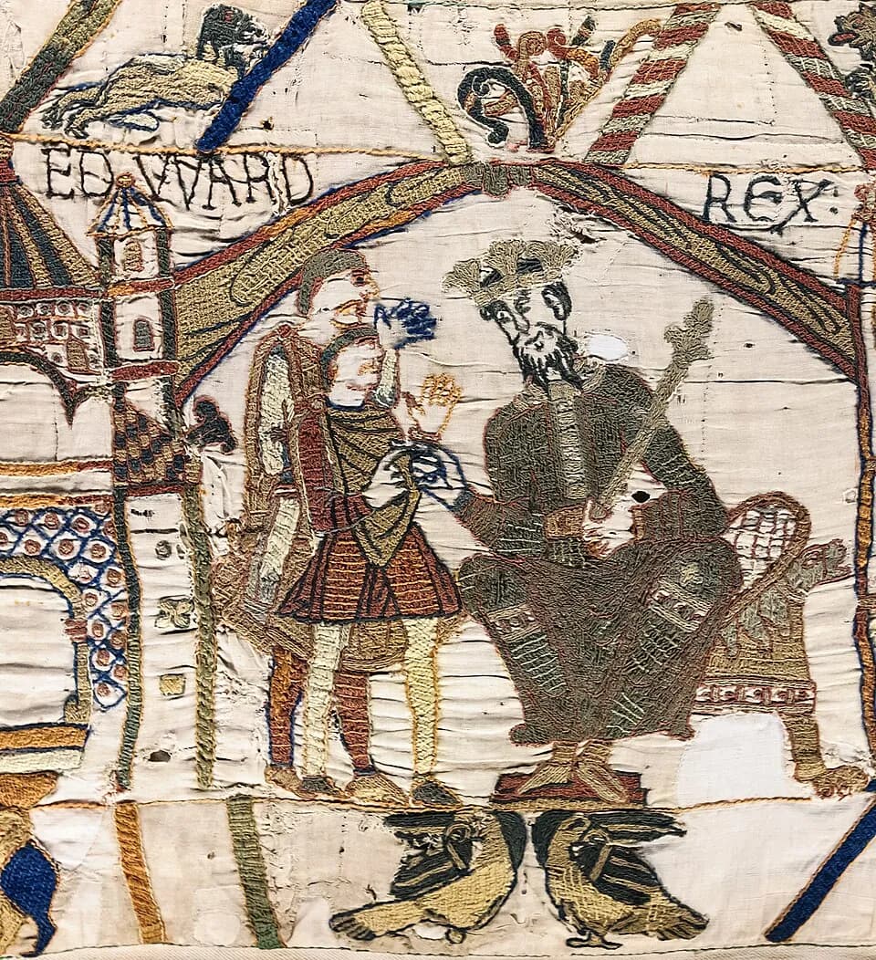 An embroidered king with a crown, beard and scepter sits enthroned under an arch labeled EDWARD REX, speaking with two standing men