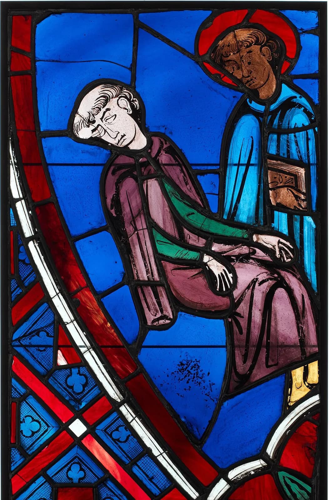 Thirteenth-century stained-glass panel in deep blue and red: a tonsured man in a purple robe sleeps sitting up with his head tilted back, while a haloed figure in a blue robe holding a book stands behind him