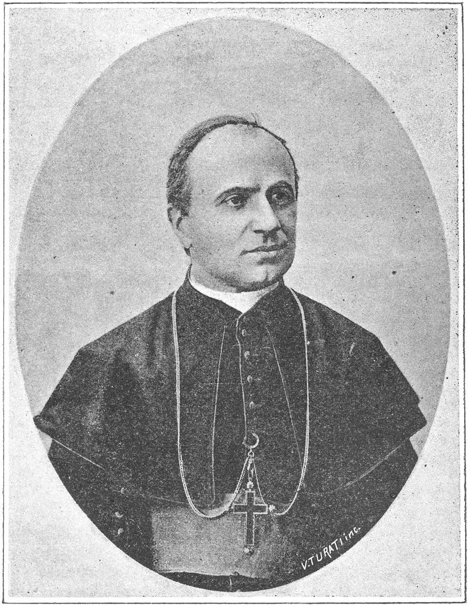A black-and-white oval portrait of Bishop Giuseppe Marello, balding and clean-shaven, in a buttoned cassock and short cape with a pectoral cross on a chain, looking to one side