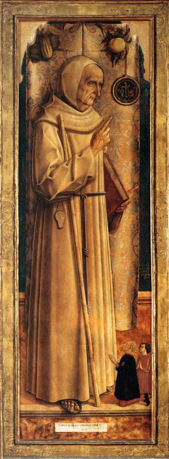Tall narrow panel painting of an old, gaunt Franciscan friar in a pale habit and hood, standing in profile with one finger raised toward a hanging disk bearing the letters IHS, a book in his other hand and a staff against his shoulder, with two small donors kneeling at his feet