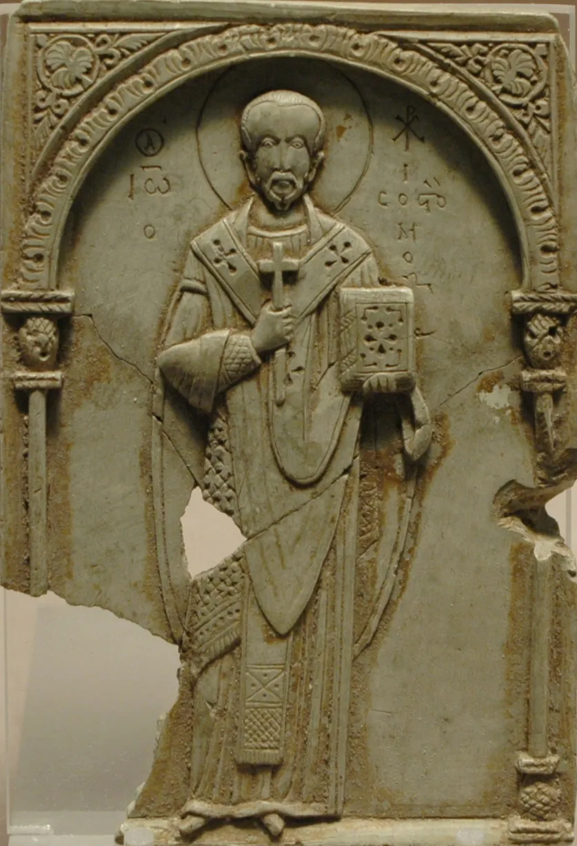 Relieve bizantino tallado en esteatita que muestra a San Juan Crisóstomo como obispo bajo un arco, sosteniendo una cruz y un libro de los Evangelios, con su nombre inscrito en griego a su lado