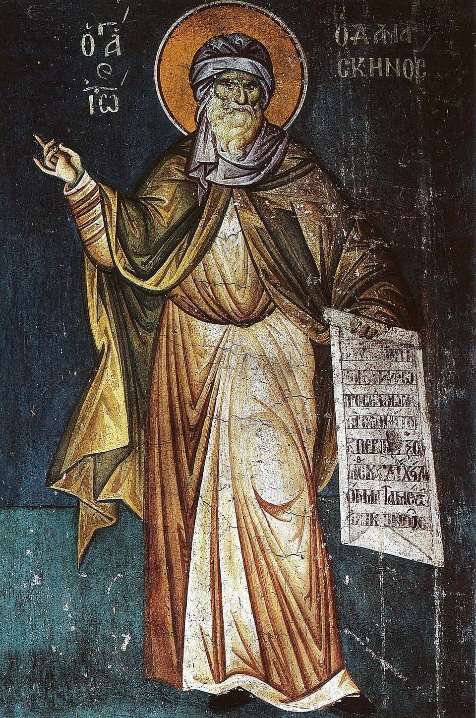 A fresco of Saint John Damascene in a turban and monastic robes, one hand raised in blessing and an inscribed scroll in the other, his name lettered in Greek on either side