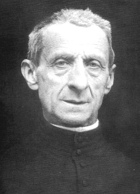 A black-and-white photograph of Leonardo Murialdo as an elderly priest with short gray hair, in a buttoned black cassock and white collar, looking straight at the camera
