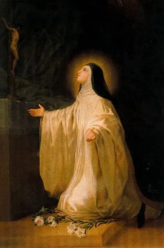 Painting of a nun in a flowing cream-white habit and black veil kneeling on a stone step with her arms spread, her face lifted toward a crucifix that stands on a ledge in the shadows at upper left; a soft halo surrounds her head and white lilies and roses lie on the step