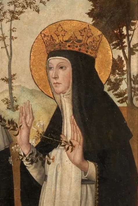 A Dominican nun in a black veil and white habit, wearing a gold crown over a gold halo, raises both hands with open palms beside a spray of white lilies, against a landscape of hills and trees