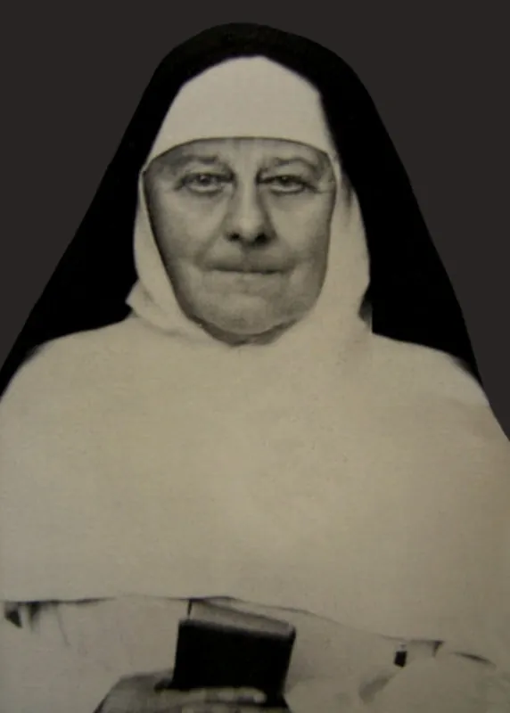 A black-and-white photograph of Mother Mary Euphrasia Pelletier as an elderly nun in a white habit, white wimple and black veil, holding a small book
