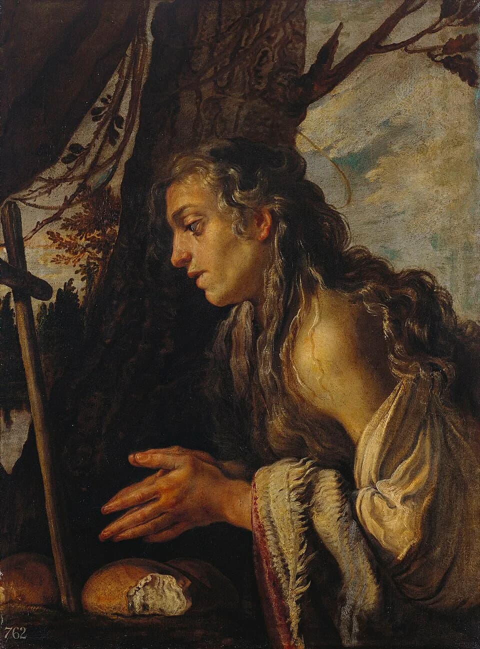 A young woman with long, loose hair and a slipping white robe kneels in profile before a rough wooden cross, her hands half raised in prayer over three loaves of bread