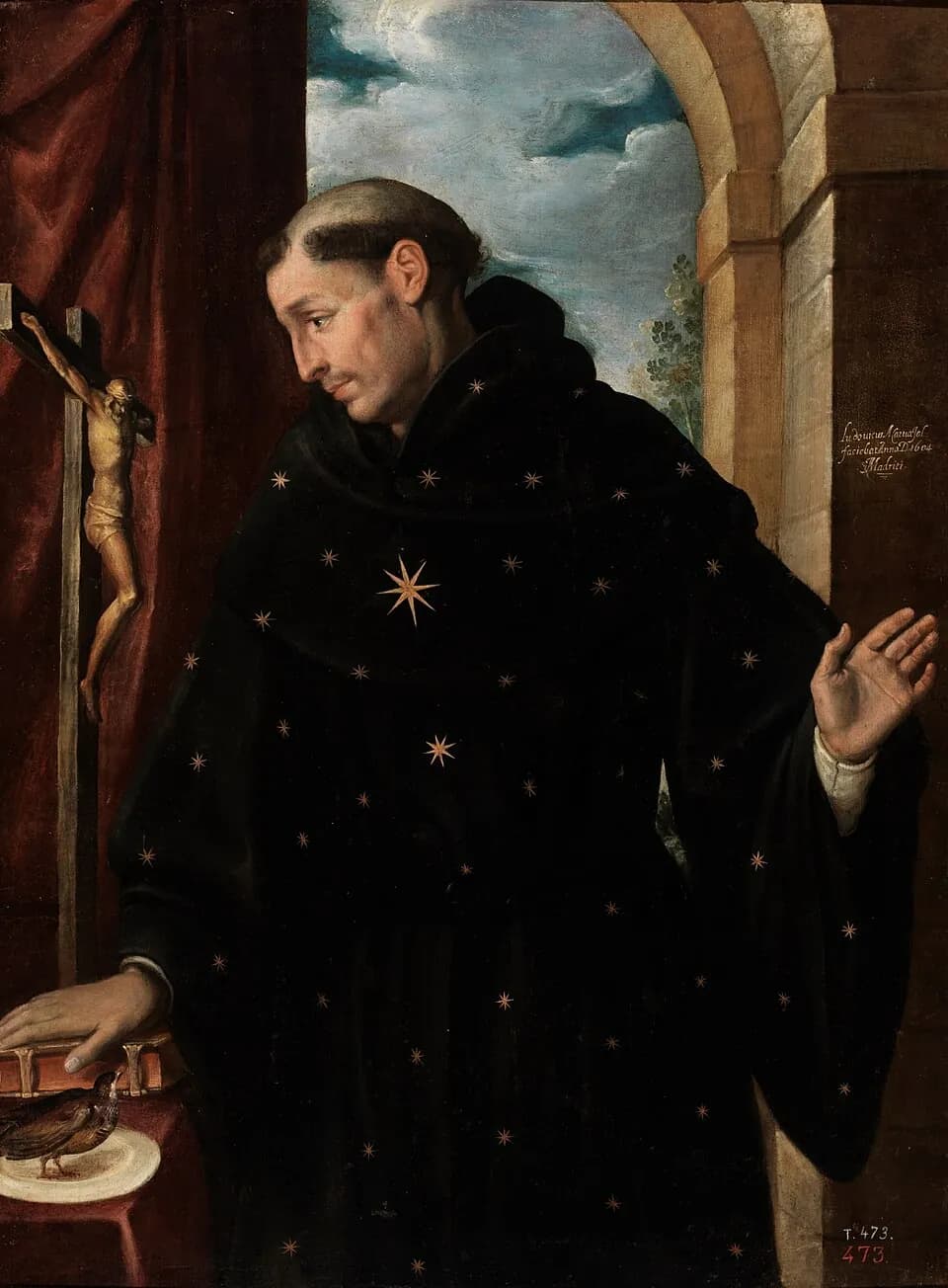A tonsured friar in a black habit scattered with gold stars turns toward a crucifix, one hand resting on a closed book beside a small bird on a plate, the other raised