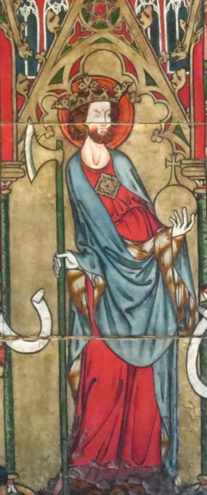 A medieval painted panel of a crowned, bearded king with a red halo, wearing a red gown and blue mantle, holding a long-handled axe in one hand and an orb topped with a cross in the other, beneath a Gothic arch