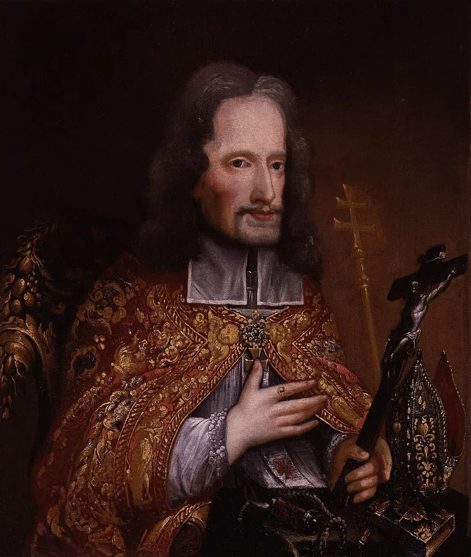 Oil portrait of Oliver Plunkett with long dark hair and a small beard, in a gold-embroidered red cope over a white collar, one hand on his chest and the other holding a crucifix, with a mitre and a double-barred cross beside him
