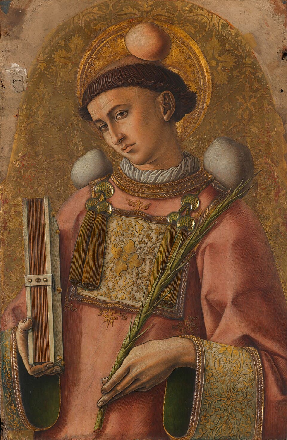 A young deacon in a rose-colored dalmatic holds a book and a martyr's palm, with a stone resting on his head, painted on gold by Carlo Crivelli
