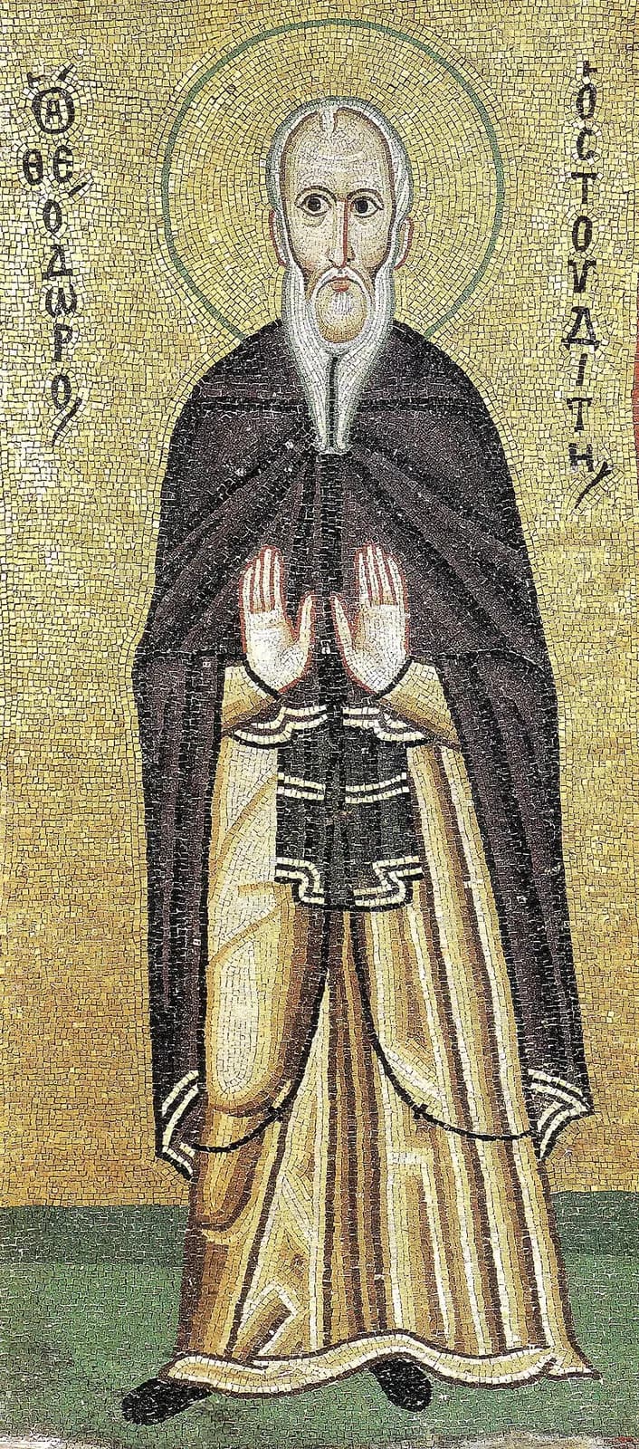 Byzantine mosaic of Saint Theodore the Studite on a gold ground, a standing elderly monk with a high bald forehead and a long white beard, in a dark mantle over a golden habit, both palms raised in front of his chest, his name in Greek letters on either side of his halo