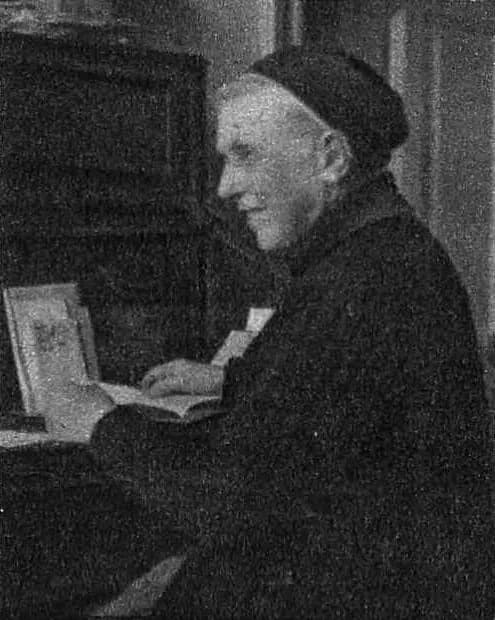 A black-and-white photograph of Mother Ursula Ledóchowska as an elderly nun in a dark habit and cap, seated in profile at a desk with an open book in front of her