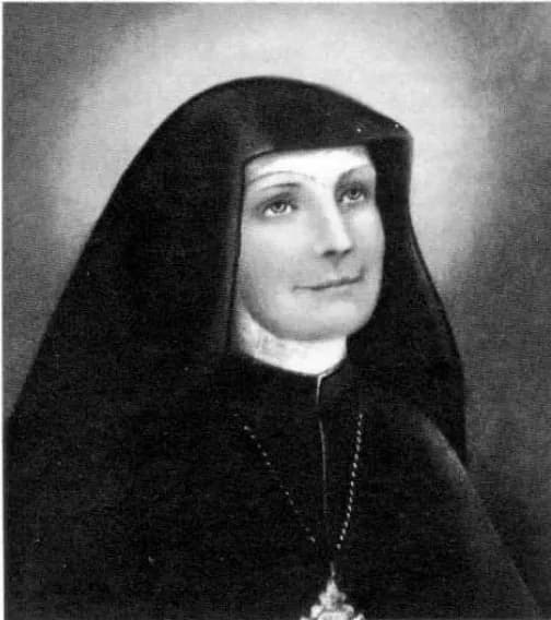 A black-and-white portrait of Vicenta María López y Vicuña in a black religious habit and veil with a white collar, a cross on a chain at her breast, smiling slightly