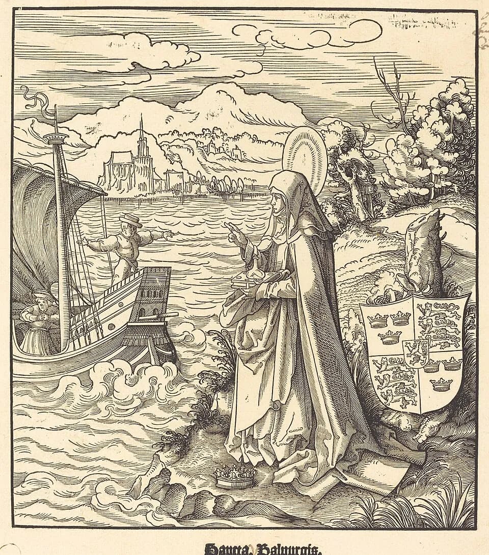 A woodcut of a haloed nun in a long habit and veil standing on a rocky shore, holding a book with a small flask of oil on it and pointing toward a sailing ship; a crown lies at her feet, a coat of arms stands beside her, and a walled town rises across the water