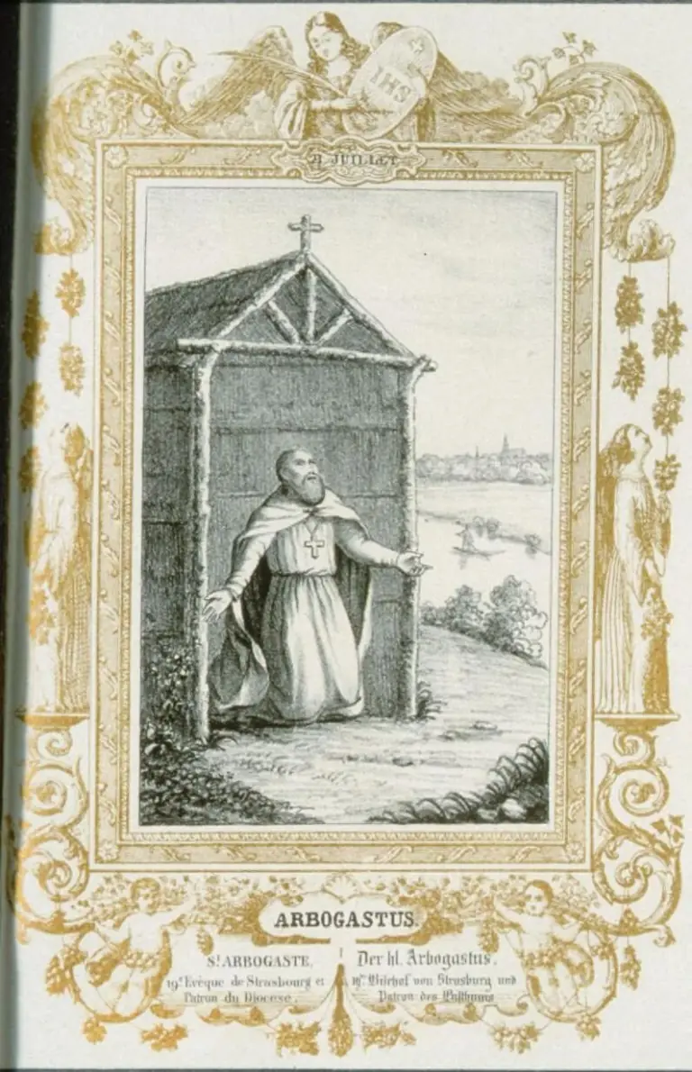 Nineteenth-century lithographed holy card of a bearded hermit in a white habit and cloak, a cross on his breast, kneeling with open arms before a wooden hut topped by a cross, with a river, a boat and a distant town behind him, inside a gold border of vines and angels