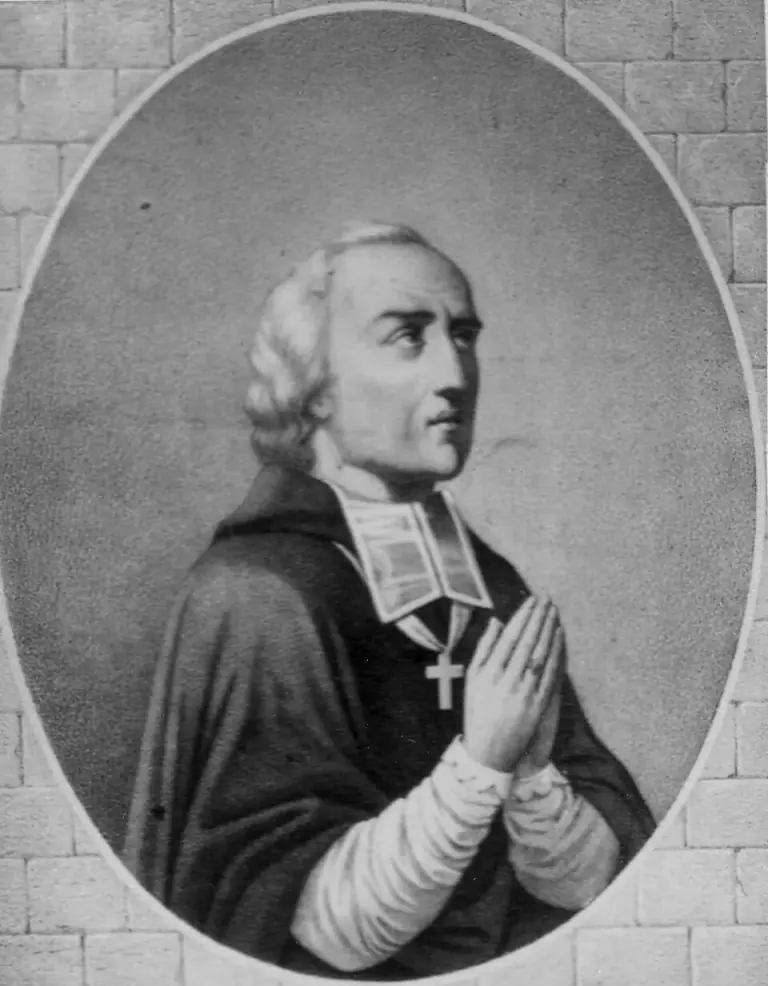 Nineteenth-century portrait of Bishop John Gabriel Taurin Dufresse in an oval frame against a stone wall: a priest with gray hair, wearing a white collar and a pectoral cross, his hands joined in prayer and his eyes raised