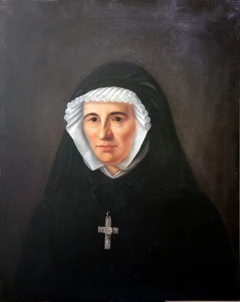 Nineteenth-century oil portrait of a middle-aged woman in a black veil over a white fluted cap and wimple, with a metal cross bearing a monogram at her breast, against a dark background