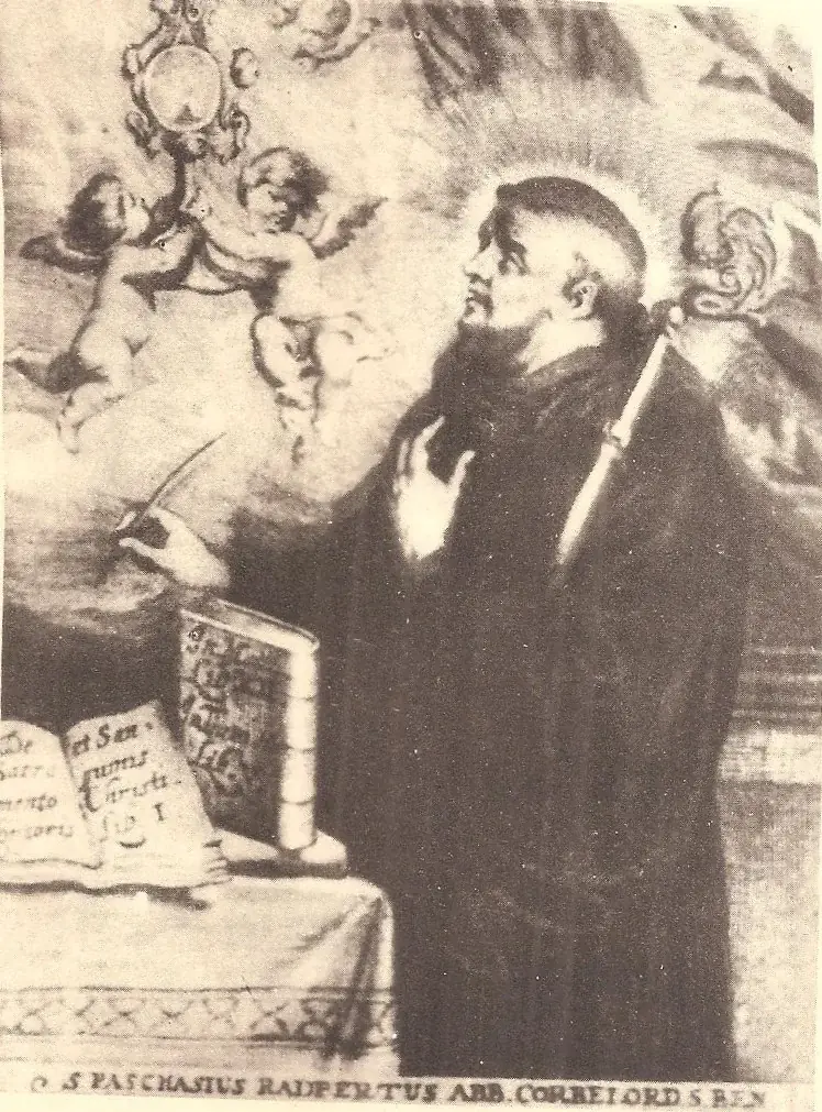 Seventeenth-century engraving of a bearded monk with a halo and a crozier, his pen raised over a table of books, turning toward two cherubs in the clouds who hold up a monstrance, with a Latin inscription naming him abbot of Corbie